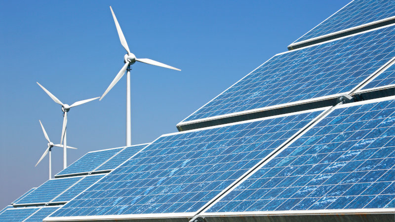 Windkraft- und Photovoltaik-Anlagen vor blauem Himmel