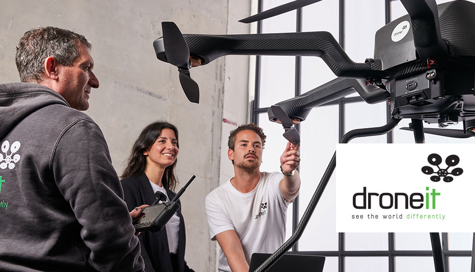 Drone it Team mit professioneller Multicopter-Drohne, Logo „droneit – see the world differently"