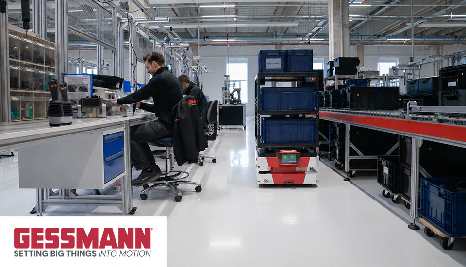 Gessmann Produktionsumgebung mit Mitarbeitern, Joystick-Bedienpult und autonomem mobilen Roboter (AMR), Logo „GESSMANN – setting big things into motion"