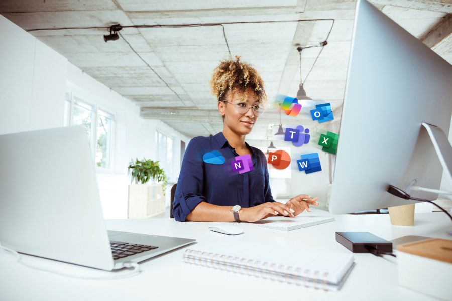 Frau am Computer mit Mirosoft 365 Logos um sie herum