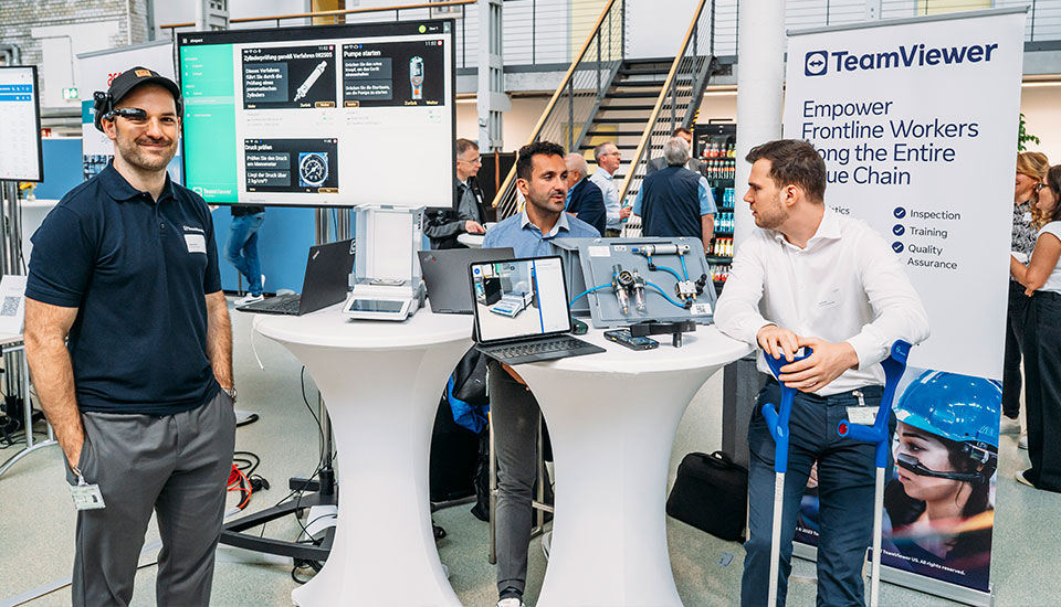 TeamViewer-Stand auf der 5G-Fachtagung: Mitarbeitende präsentieren Remote-Support-Lösungen mit Laptops, Smart Glasses und Demonstrations-Equipment