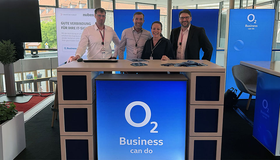 Vier Personen vom o2 Business Team am gemeinsamen Messestand mit ekom21 auf der eXPO26 in Hanau.