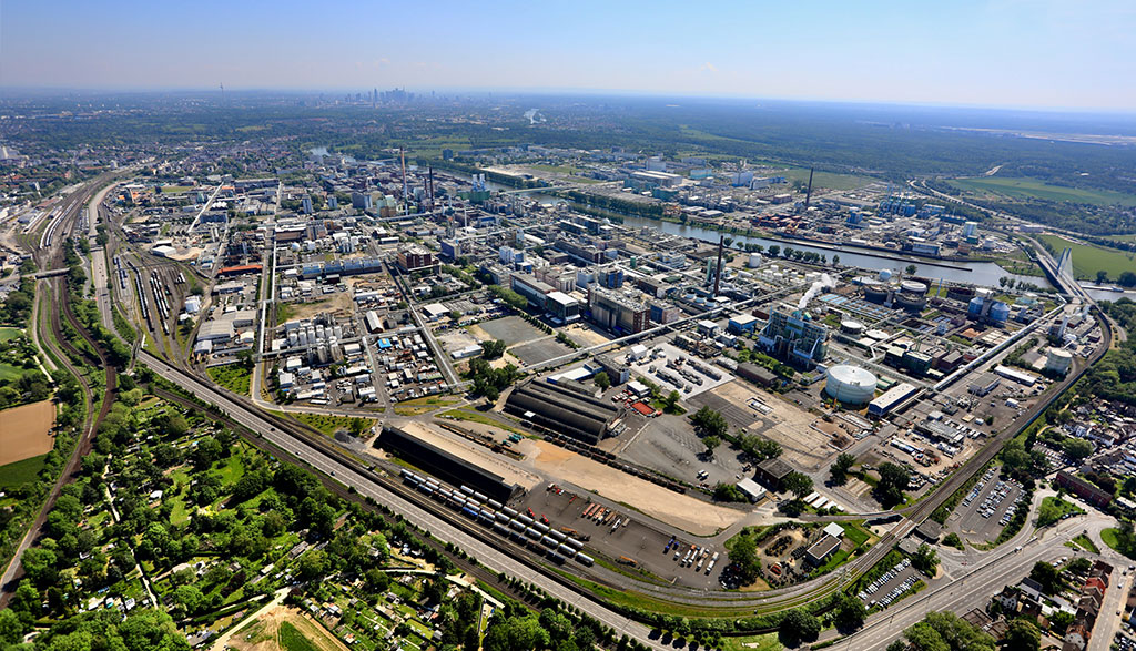 Luftaufnahme des Industrieparks Höchst mit vielen Industriegebäuden, Straßen und gleisen.