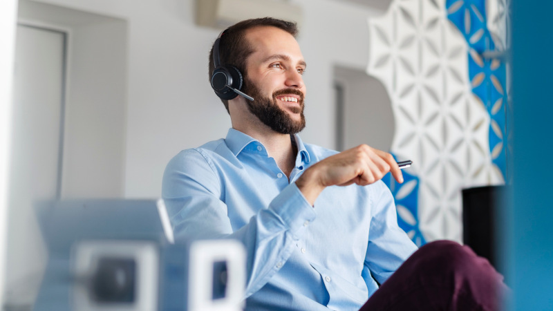 Mann mit Headset telefoniert über eine virtuelle Telefonanlage