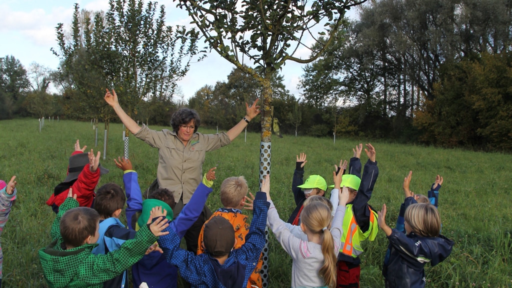 Kinder im Kreis um eine Erzieherin