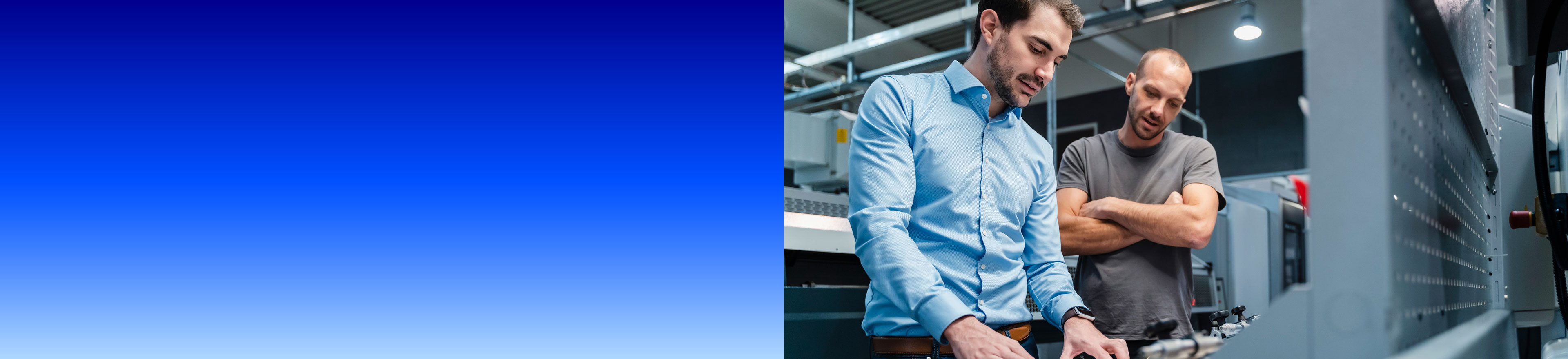 Zwei Männer im Industrieumfeld besprechen Unterlagen an einer Maschine, mit blauem Farbverlauf über der linken Bildhälfte.